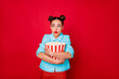 © deagreez - Pretty lady holding popcorn container afraid everything after scary film wear casual outfit isolated red background