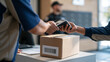 © AnastasiiaRozhmanova - Close up of delivery driver scanning barcode on cardboard box with handheld device at apartment building reception desk, lobby security guard watching, parcel lockers visible