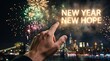 © Lemon Pop Studio - Man hand pointing at glowing New Year New Hope text over city fireworks skyline