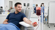 © Golden Eagle - Healthy young man donating blood during medical session in modern hospital interior
