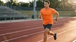 © Lela - Determined Athletic Young Man Running on Outdoor Track in Warm Golden Hour Light