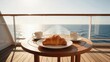 © HETA DESIGN - Breakfast with croissant and two cups of coffee on a round teak table on a sunny yacht deck with glass railing overlooking the open sea - Luxury cruise travel and morning at sea