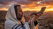© CaptureCollabStudios - Jewish man in tallit blowing shofar horn outdoors at sunset Rosh Hashanah and Yom Kippur concept