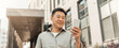 © Prostock-studio - Smiling Asian Man In His 30s Holding Smartphone Outdoors, Enjoying Mobile Interaction, Looking Happy At Modern Urban Location. Engaging With Technology For Business Concept.