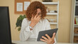 © Krakenimages.com - Woman holding tablet pinches bridge of nose with hand, glasses and wristwatch visible at desk in building; fatigue.