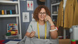 © Krakenimages.com - Woman dressmaker with yellow measuring tape holds smartphone to ear while adjusting fabric on table in sewing studio; calm creativity.