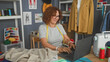 © Krakenimages.com - Woman holding and measuring a beige garment with hands, tape measure around neck and machine nearby in a design studio; creative focus.