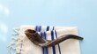© Rocha Santos - Brown shofar ram's horn resting on a white and blue striped tallit prayer shawl against a light blue background for Rosh Hashanah and Yom Kippur