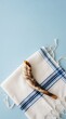 © Rocha Santos - Ram's horn shofar resting on white tallit with blue stripes and fringes against light blue background for Rosh Hashanah and Yom Kippur
