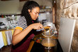 © Alvaro Lavin/Stocksy - Woman tasting pasta while cooking in kitchen