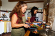 © Alvaro Lavin/Stocksy - Women friends cooking healthy food using digital tablet