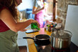 © Alvaro Lavin/Stocksy - Woman pouring oil into frying pan on stove