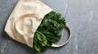 © MD ISMAIL - Fresh kale and spinach leaves on a grey stone surface