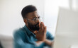 © Prostock-studio - Worried Expression On Focused Black Male Professional Deep In Thought While Looking At Computer Screen In Modern Office. Engaged In Problem Solving During Work Hours, Business Concept.