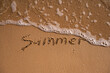 © ZeDesign - A close-up shot captures the word “Summer” written in the wet sand. A gentle wave rolls in and starts to wash away the letters, symbolizing the fleeting nature of the season.