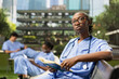 © DC Studio - Medical student in blue scrubs looks up from a book on a campus bench
