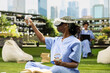 © DC Studio - Black medical student in blue scrubs uses a VR headset and controllers outdoors on campus, exploring virtual reality for healthcare training.