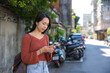 © leungchopan - Woman using mobile phone standing on street in taiwan