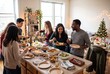 © Pol - Diverse friends serving homemade dishes at a christmas potluck