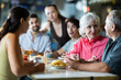 © JackF - Family day. People group drink and eat in cafe, socializes. Relatives chatting, joking, speaking, have nice conversation. Rare family gatherings or traditional meeting of colleagues on day off