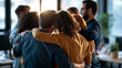 © Kateryna - Rear view of a happy multiethnic group of colleagues standing together with arms around each other in an office corporate workforce seen from behind facing the bright windows desks and
