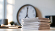 © Kateryna - Large wall clock above a neat stack of white documents on a desk clock hands near twelve light wall and soft daylight minimal composition wall clock passage of time stack