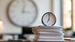 © Kateryna - Large wall clock above a neat stack of white documents on a desk clock hands near twelve light wall and soft daylight minimal composition wall clock passage of time stack