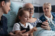© DC Studio - Technology, child and patient use a smartphone together in a hospital room as the girl taps the screen beside a senior man, for intergenerational connection, digital inclusion and family support.