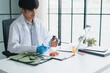 © Charlie's - Cardiologist Explaining Heart Health and Holding Anatomical Heart Model During Medical Consultation in Modern Clinic.