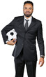 © fotofabrika - Man in a suit holds a soccer ball while smiling at the camera in a studio setting