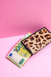 © Metadancer - Leopard print wallet holding 100 euro banknote on pink studio