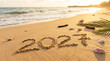 © TerraPixels - 2027 written in sand on a tropical beach at sunset