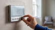 © Nei Mar - Hand adjusting a modern thermostat on a living room wall