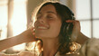 © ivlianna - Smiling woman in her 30s with headphones enjoying music indoors in bright light