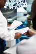 © DC Studio - Traffic control, paperwork and document exchange as operations staff hand printed reports across monitoring desk. Coordination, reporting and workflow support road surveillance teams in control room.