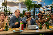 © DC Studio - Sports viewing, projector and friends as guests gesture and react while watching screen beyond frame beside food and drinks. Fan culture, competition and socializing shape entertainment outdoors.