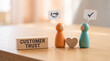 © ViskBx - Wooden figures representing customer trust with a handshake icon and a checkmark symbol on a wooden table