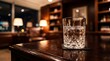 © Yuliyanti - Crystal glass of water with ice cubes on a polished wooden table in a cozy lounge