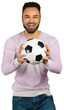 © fotofabrika - Man smiles while holding a soccer ball wearing a light sweater indoors