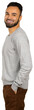© fotofabrika - Man standing with hands in pockets wearing a gray sweater and brown pants