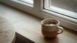 © Eva - Ceramic cup of tea on a wooden windowsill in winter light