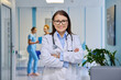 © Valerii Honcharuk - Smiling female doctor with arms crossed in a hospital