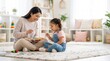 © evastar - A smiling speech therapist woman and a little girl playing with a colorful xylophone on the floor