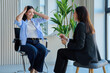 © Valerii Honcharuk - Smiling woman talking to female psychologist during therapy session in office