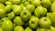 © Valeriia - Full frame background of small green apples with bright light highlights. Fresh organic fruits texture.