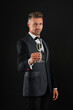 © be free - Elegant tuxedo man hold glass of champagne isolated on black. Celebrating success. Cheers. Tuxedo man look formal. Celebrate with champagne. Cheering celebrating. Man in tuxedo. Personal confidence
