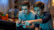 © Jarp - Two teenage boys playing video games on console controller at home living room, focused friends sharing gaming excitement and multiplayer strategy