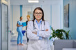 © Valerii Honcharuk - Mature female doctor with arms crossed in clinic corridor portrait shot