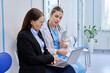 © Valerii Honcharuk - Pharma representative showing laptop to female doctor in clinic hallway