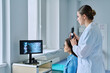© Valerii Honcharuk - Female trichologist dermatologist examining patient hair with trichoscope in clinic